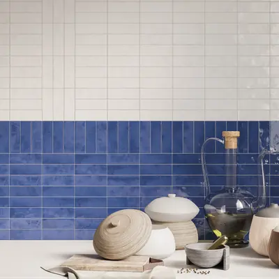 Wall of stacked white and cobalt bejmat behind ceramic vessels on a counter