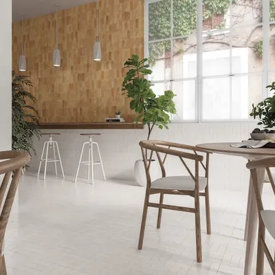 Cafe interior with a sand bejmat wall and pale floor beside a tall window