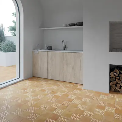 Kitchen floor in ochre bejmat with patterned tiles set through it below an arched window