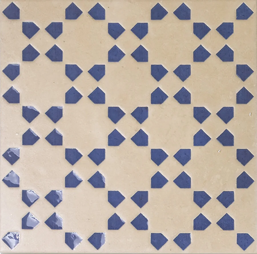 Pale sand bejmat tile with a repeating geometric motif inlaid in blue