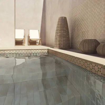 Pool edged with a band of patterned bejmat below a plastered wall