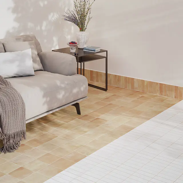 A pale sand bejmat floor beneath a low sofa in a plastered room