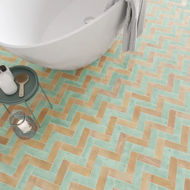 Turquoise and natural terracotta bejmat tiles laid together in a herringbone floor