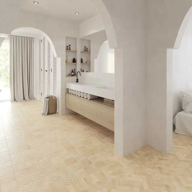 A white bejmat bathroom floor laid in herringbone beneath a freestanding bath