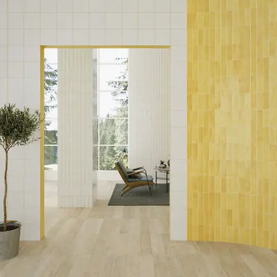Yellow glazed bejmat wall beside a doorway opening onto a pale room