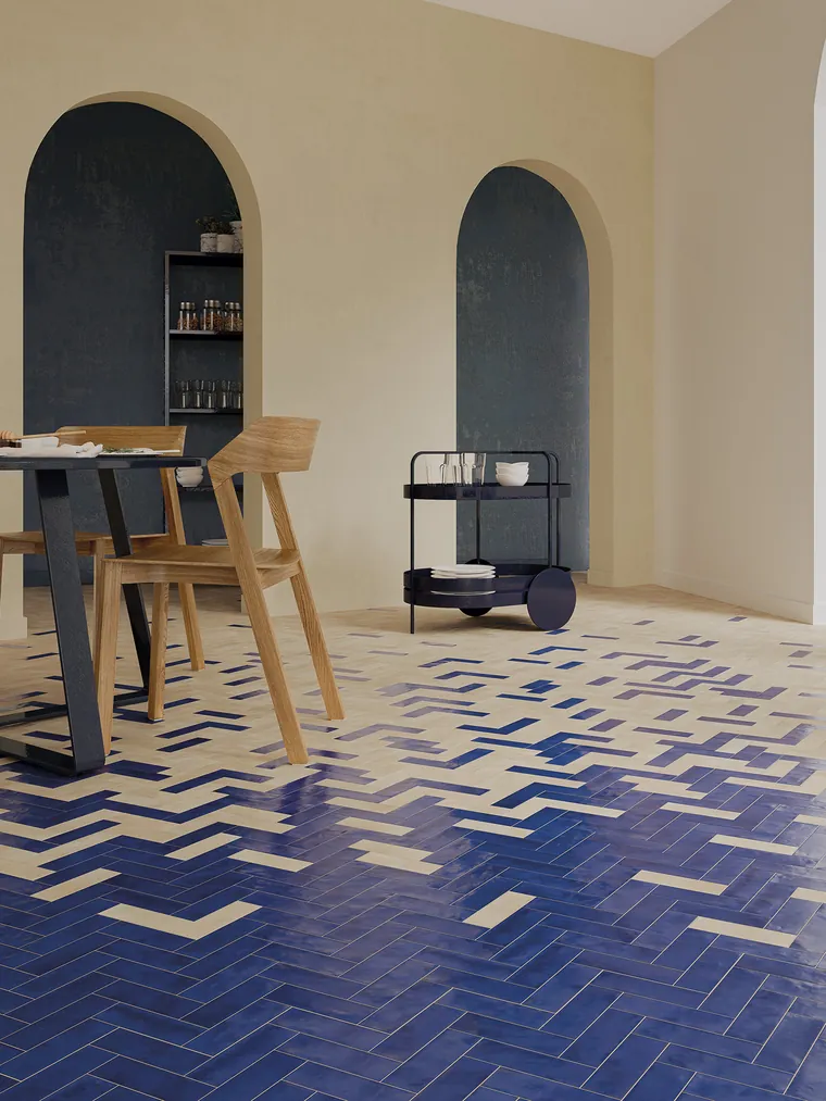 Blue and sand bejmat terracotta tiles laid in herringbone across a restaurant floor