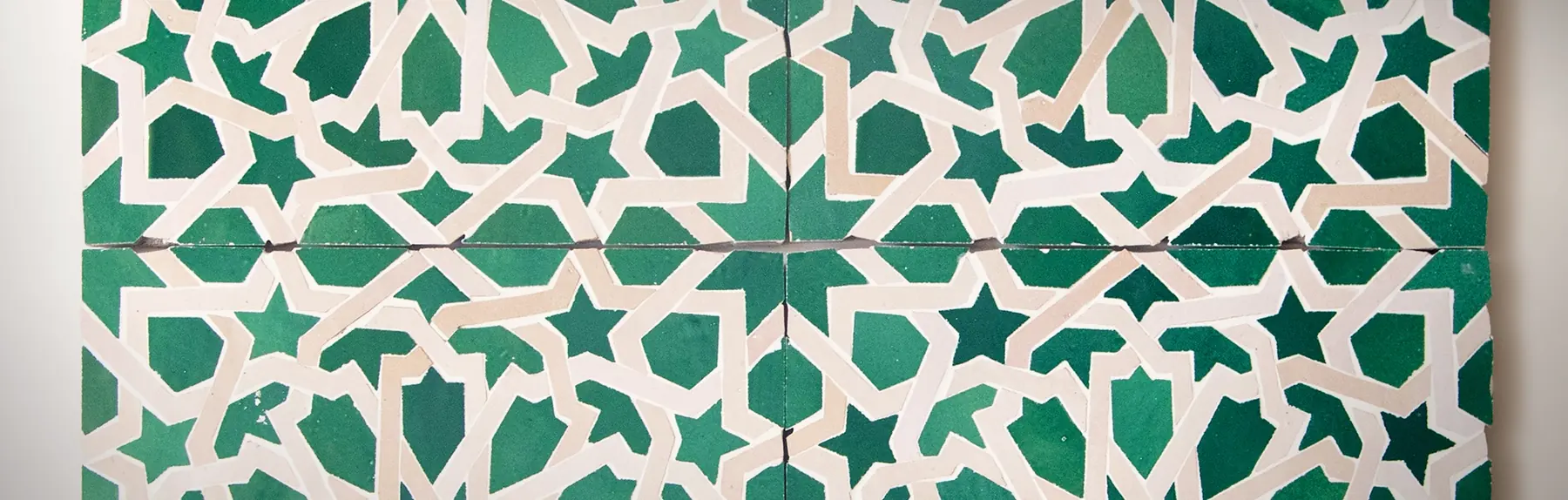 Traditional zellige star pattern hand-cut in green and beige glazes