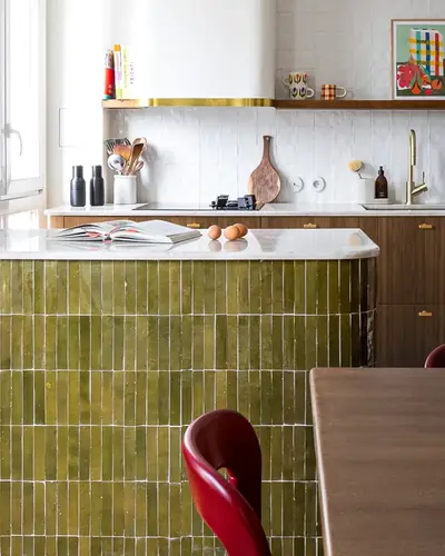 Olive green rectangular zellige tiles stacked across a kitchen island front
