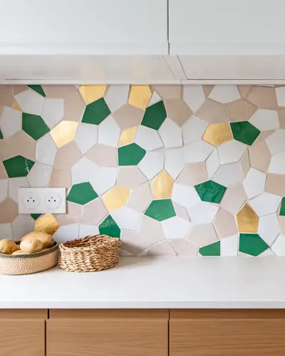 Green, yellow and white five-sided zellige tiles set across a kitchen splashback