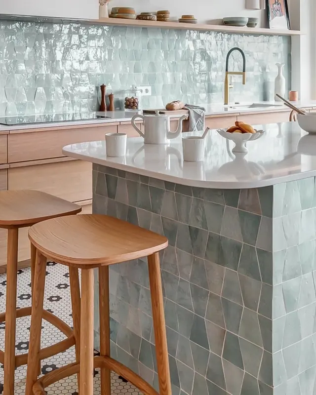 Turquoise zellige tiles wrapping a kitchen island and continuing across the splashback
